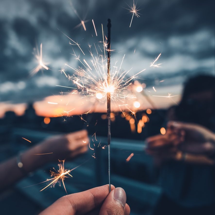 photo of person holding lighted sparkler